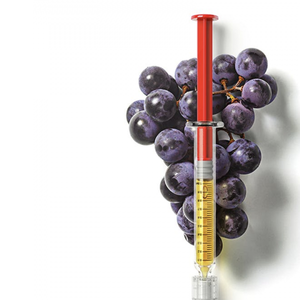Photo of a Syringe over a bunch of grapes